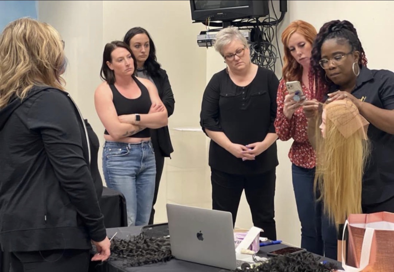 Sandra Atoge demonstrating a practical technique on a human hair training mannequin at iHobbs Academy