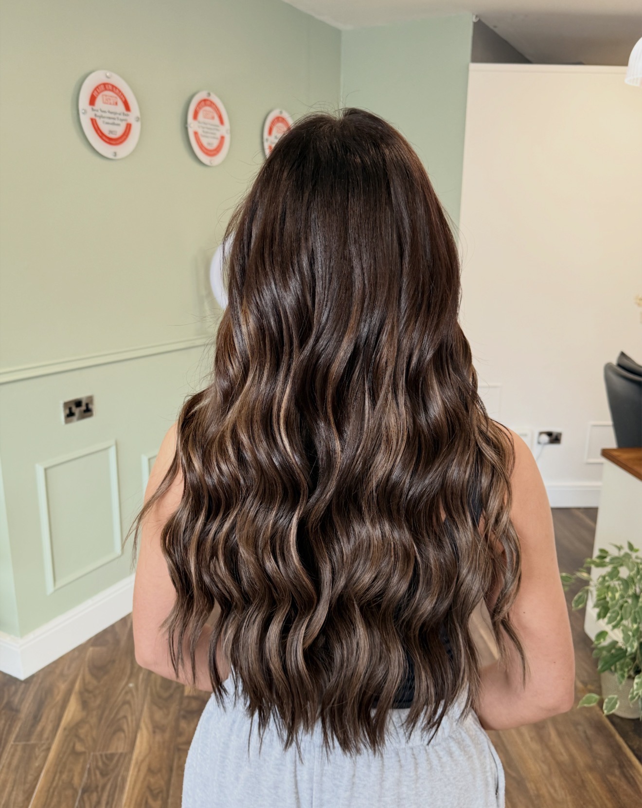Finished iHobbs brunette hair extensions result with long, softly waved length and natural movement